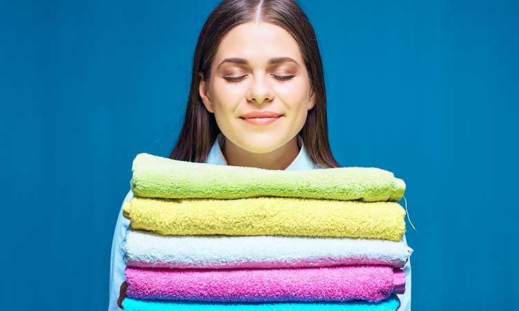 Good smelling laundry without fabric softener, woman smells fresh laundry