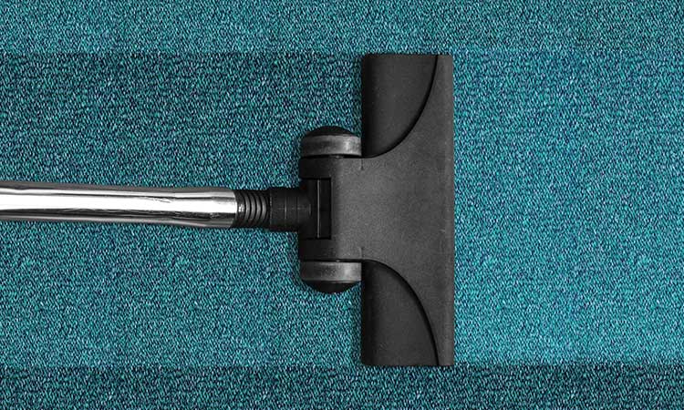 Vacuum carpet, vacuum cleaner on green carpet
